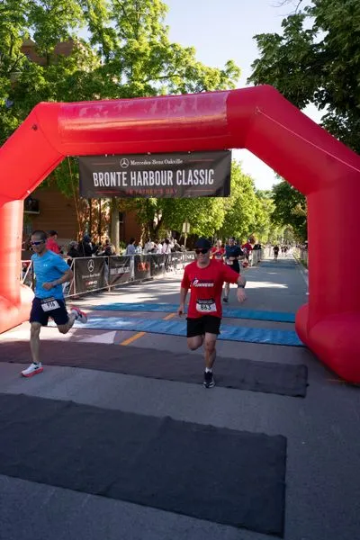 Bronte Harbour Classic 5K 2026 official race photo: Finish Line, Kristopher Y., Mercedes-Benz Oakville, CIBC, Be Active Physio, Bronte Runners Club, Kids Area.